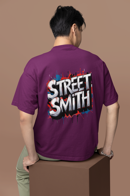 Man wearing a burgudy oversized t-shirt with 'STREET SMITH' text on the back against a brown background
