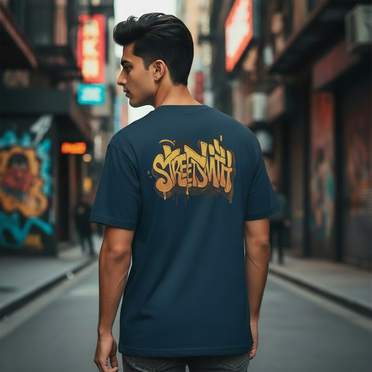 Man wearing a dark blue oversized t-shirt with 'Streetlife' design on a city street.