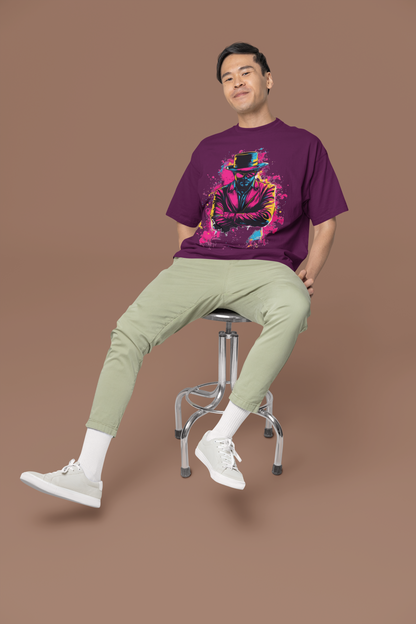 Man sitting on a stool wearing a purple oversized t-shirt with a colorful graphic design on a brown background